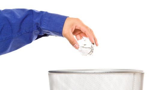 Hand Throwing Crumpled Paper into the Trash