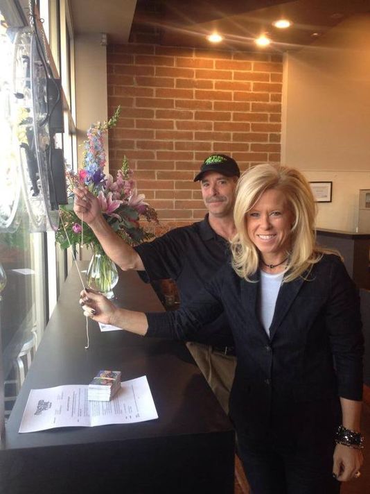 SaraAnn Hales Fractured Prune Doughnuts of Canton turning on the open sign